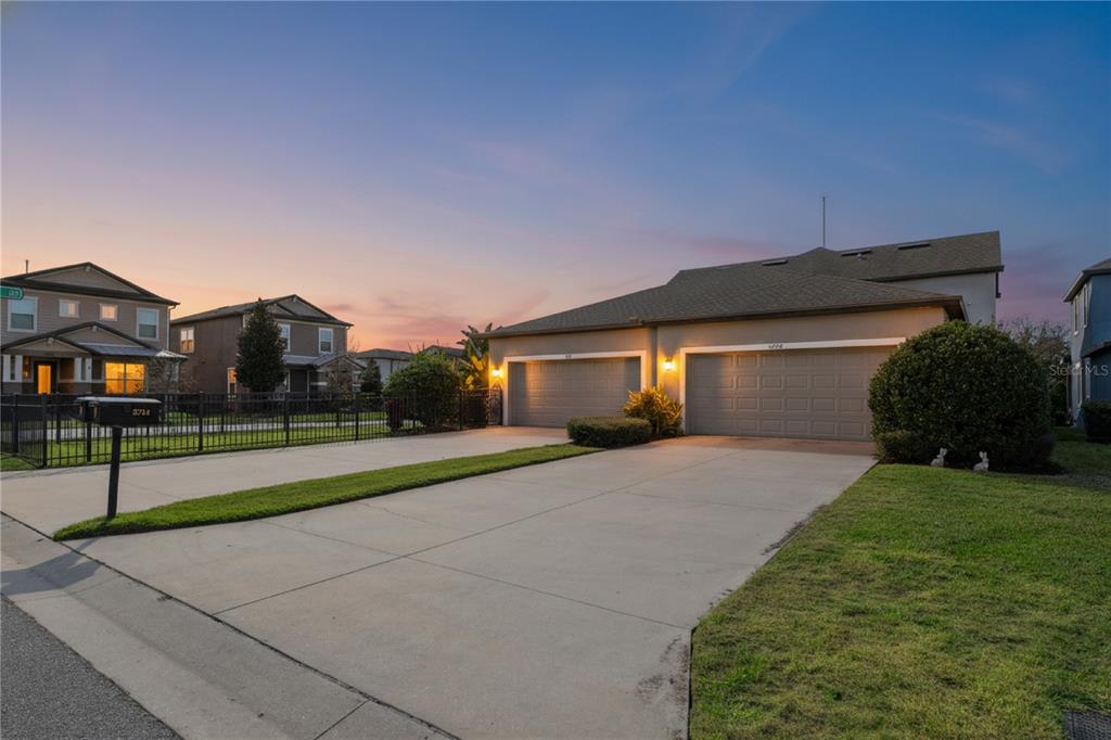 A two-car garage with a concrete driveway sits in front of a suburban house — 5714 COLONY GLEN ROAD, LITHIA, FL