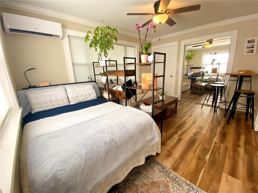 A bedroom features a bed, a small sofa, a coffee table, and a metal shelving unit — 828 22ND AVENUE N Apt. West, ST PETERSBURG, FL