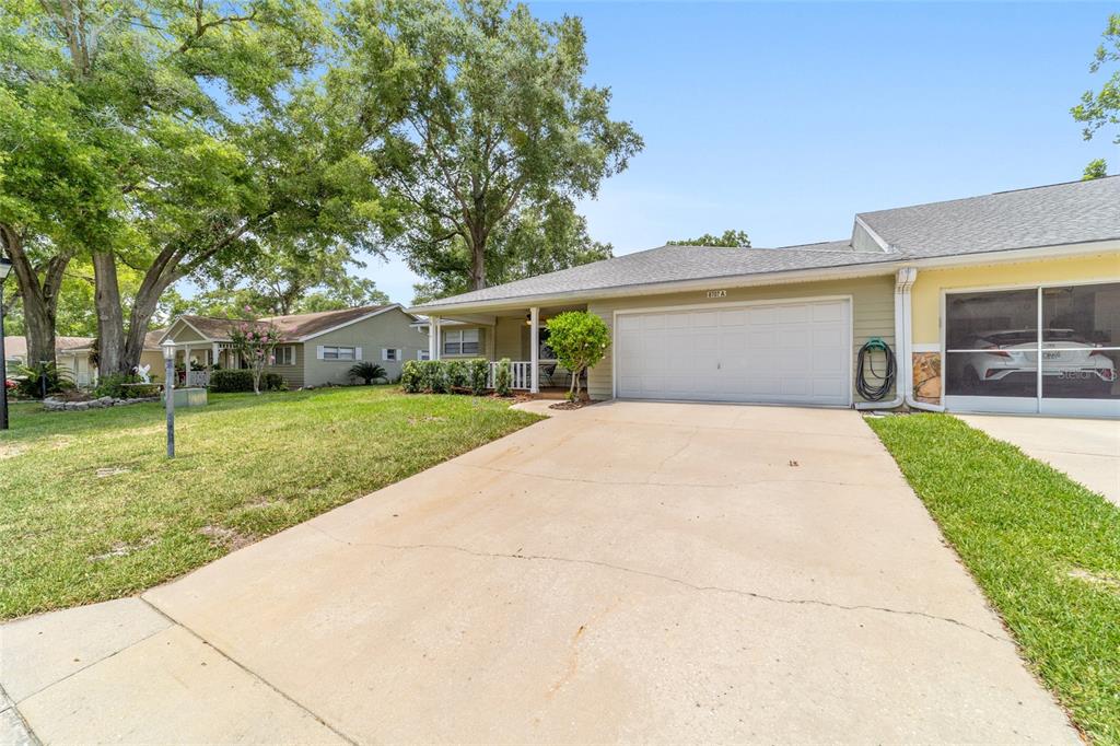 A single-story house with a two-car garage, a concrete driveway, and a covered front porch — 8707 SW 95TH LANE UNIT A, OCALA, FL