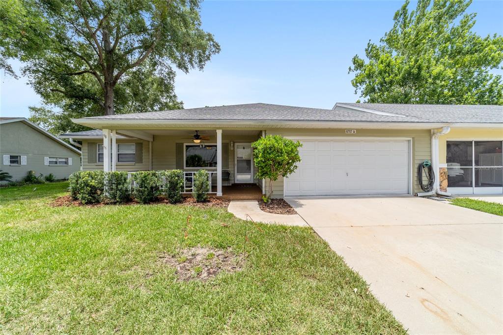 A single-story house with a front porch, a two-car garage, and a green lawn — 8707 SW 95TH LANE UNIT A, OCALA, FL