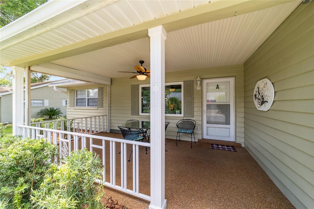 A covered front porch features a white railing, a ceiling fan, and a glass-paneled door — 8707 SW 95TH LANE UNIT A, OCALA, FL