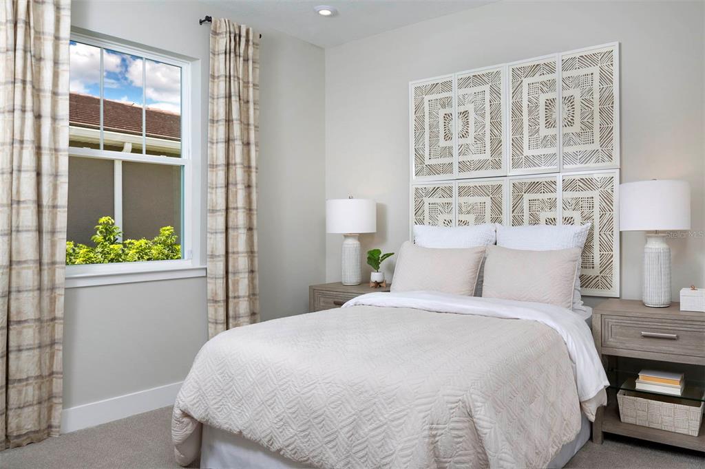 A bedroom features a bed with patterned wall art, two nightstands, and a window with curtains — 17760 STILLNESS COURT, VENICE, FL