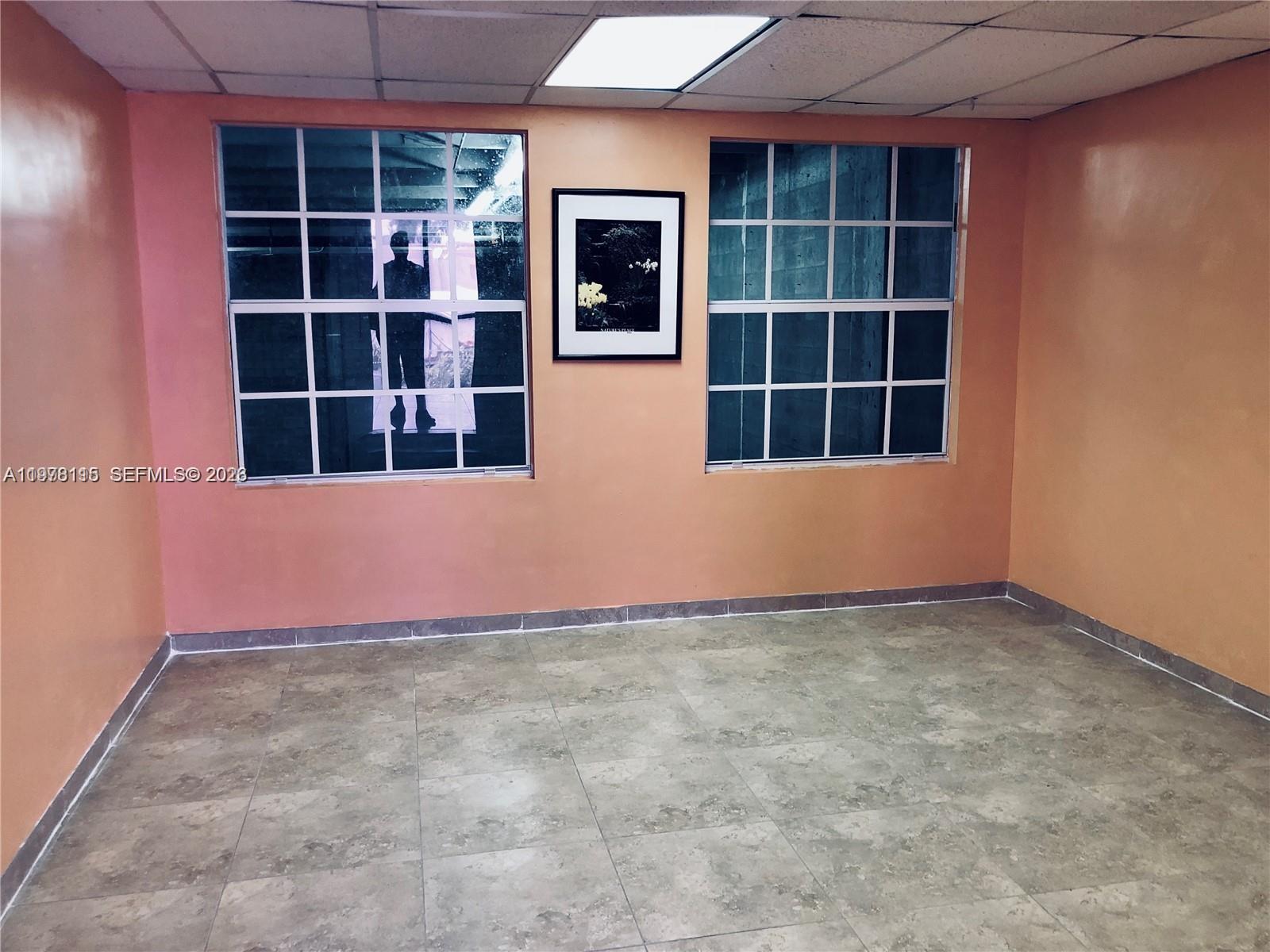 An empty office space features white walls, a tiled floor, and a doorway leading inside — 6850 NW 77th Ct # 6850, Medley FL 33166, MEDLEY, FL