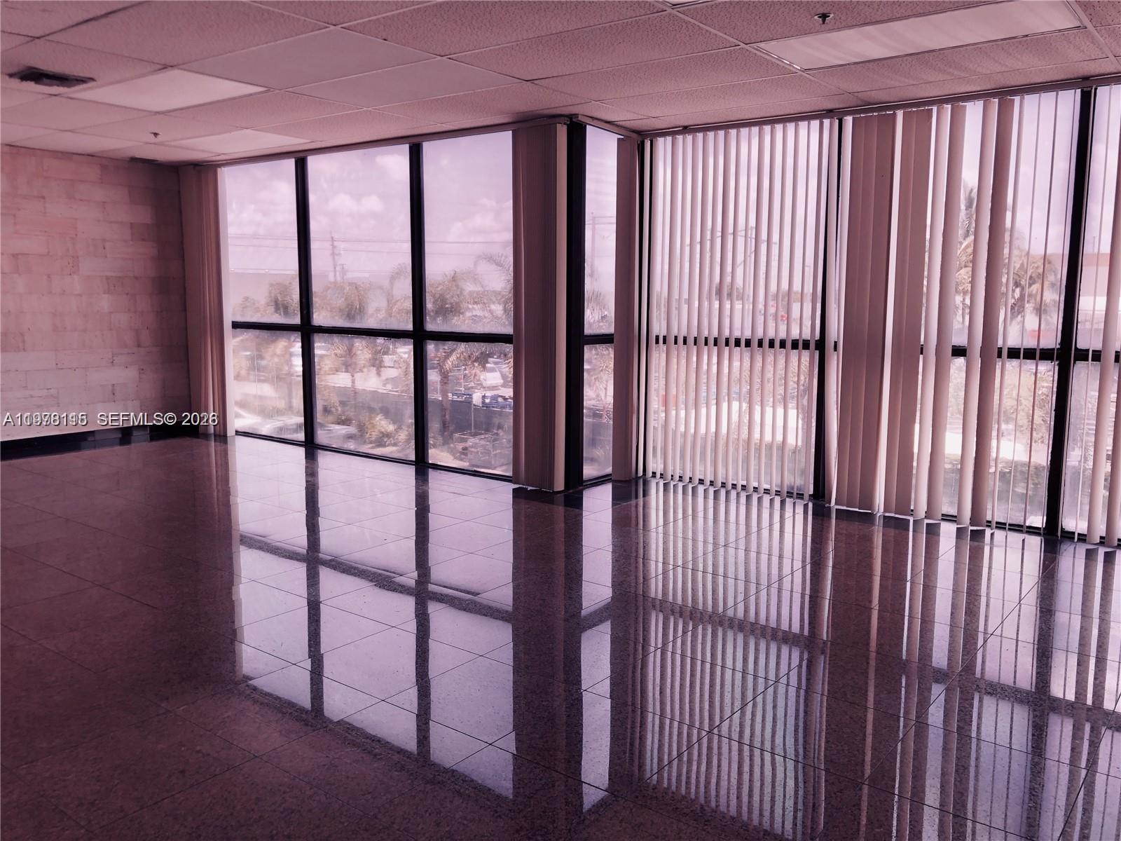 An industrial warehouse space features concrete walls, a roll-up door, and a small office enclosure — 6850 NW 77th Ct # 6850, Medley FL 33166, MEDLEY, FL