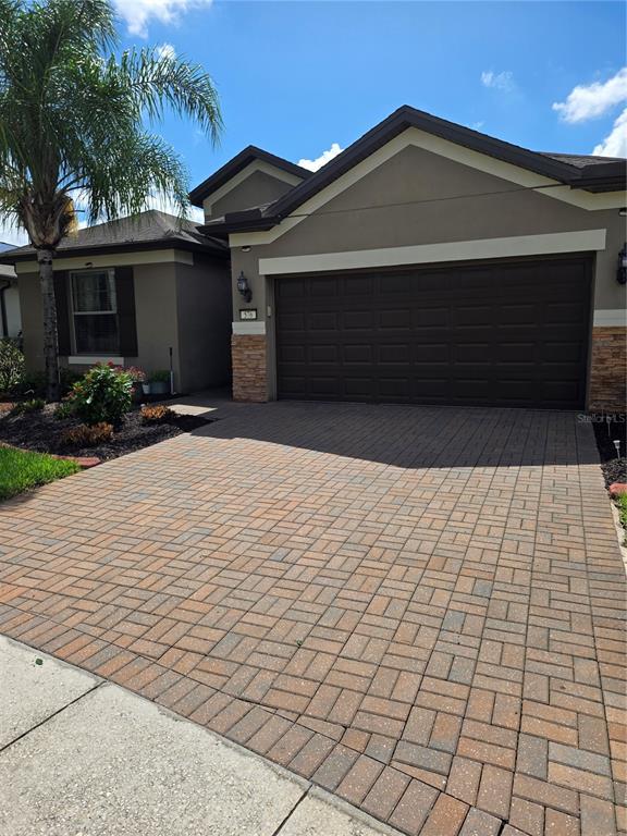 A single-story house with a brown garage door and a brick paver driveway — 576 CANTABRIA DRIVE, DAVENPORT, FL