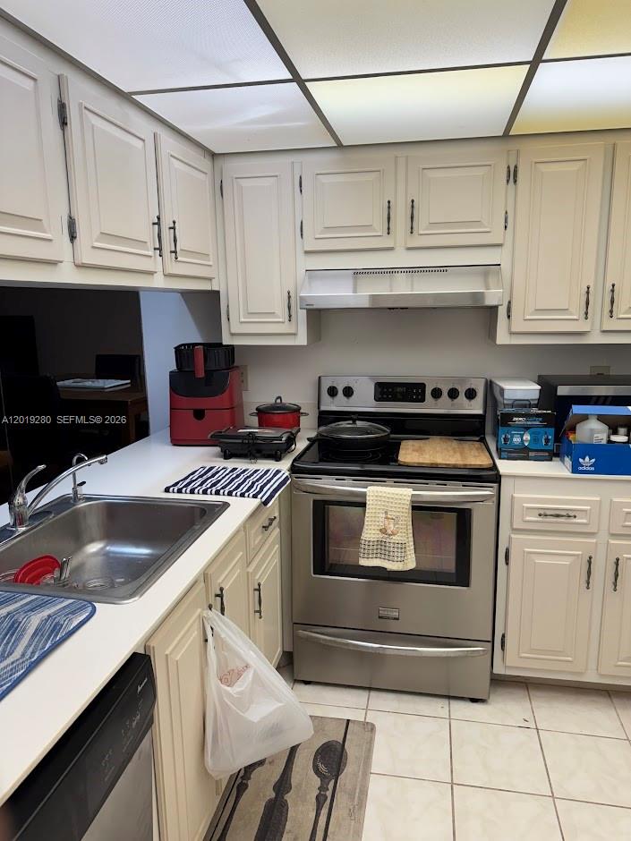 A kitchen features off-white cabinets, stainless steel appliances, and a drop ceiling with lights — 4602 Martinique Way # A2, Coconut Creek FL 33066, COCONUT CREEK, FL
