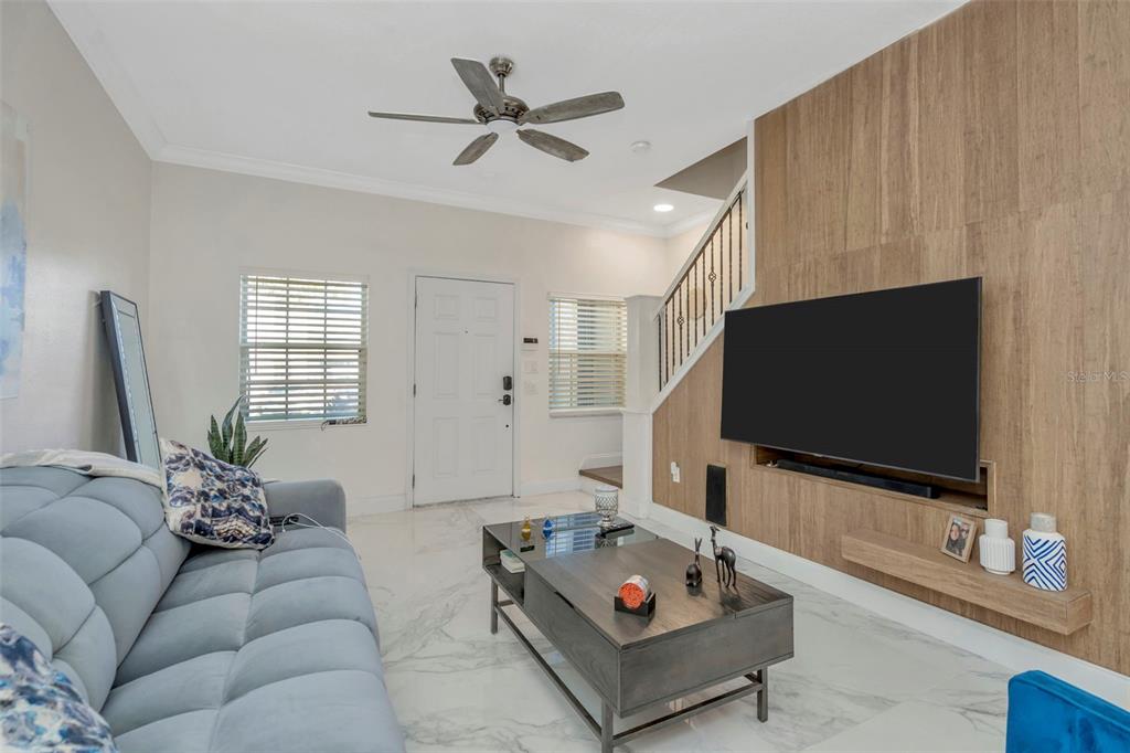 A dining area with a white table and chairs sits in front of a living room — 6765 LAKE ROCHESTER LANE, GIBSONTON, FL