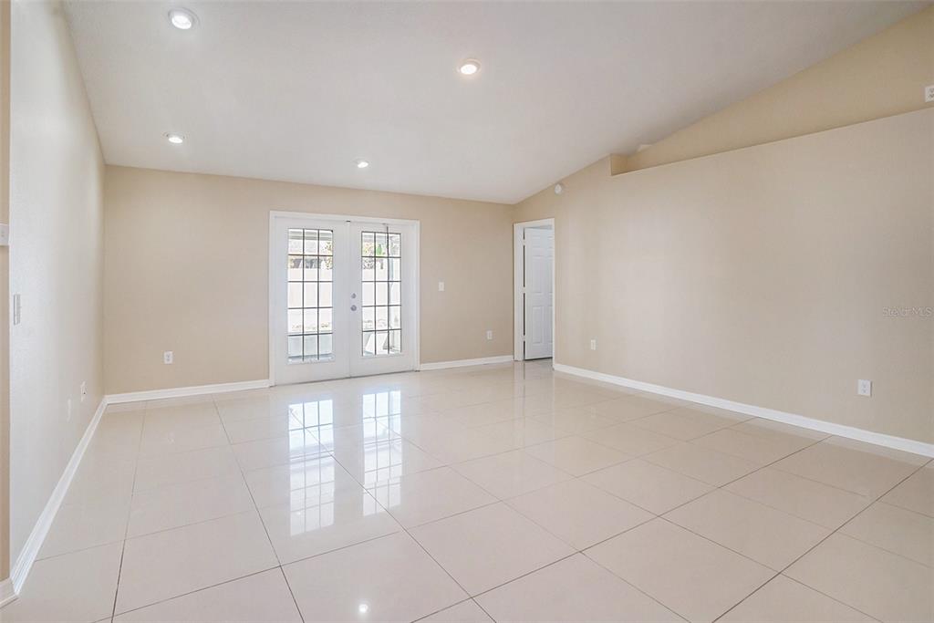 An empty room features beige walls, recessed lighting, and large, light-colored floor tiles — 12712 LONGCREST DRIVE, RIVERVIEW, FL