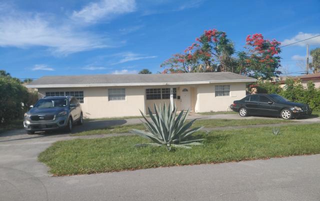 A single-story house with a light-colored exterior, two parked cars, and a large agave plant — 200 N Ware Drive, West Palm Beach FL 33409, WEST PALM BEACH, FL