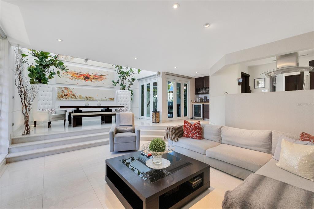 A modern living and dining area with white tile floors, a sunken lounge, and artwork — 2008 ESPAÑA STREET, SAN JUAN, PR