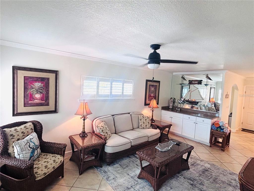 A living room features wicker furniture, a sofa, a ceiling fan, and a wet bar — 19417 GULF BOULEVARD UNIT B209, INDIAN ROCKS BEACH, FL