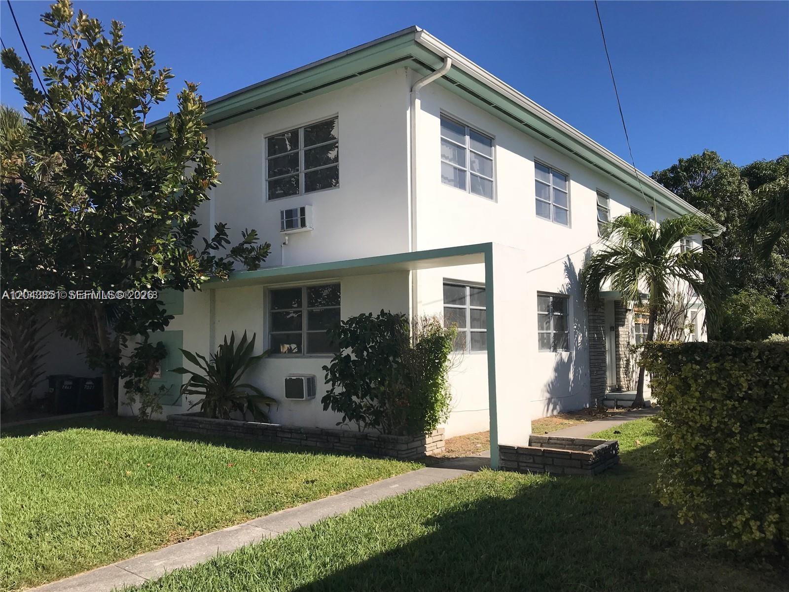 A two-story white apartment building features a flat roof, green trim, and a front walkway — 7821 Byron Ave, Miami Beach FL 33141, MIAMI BEACH, FL