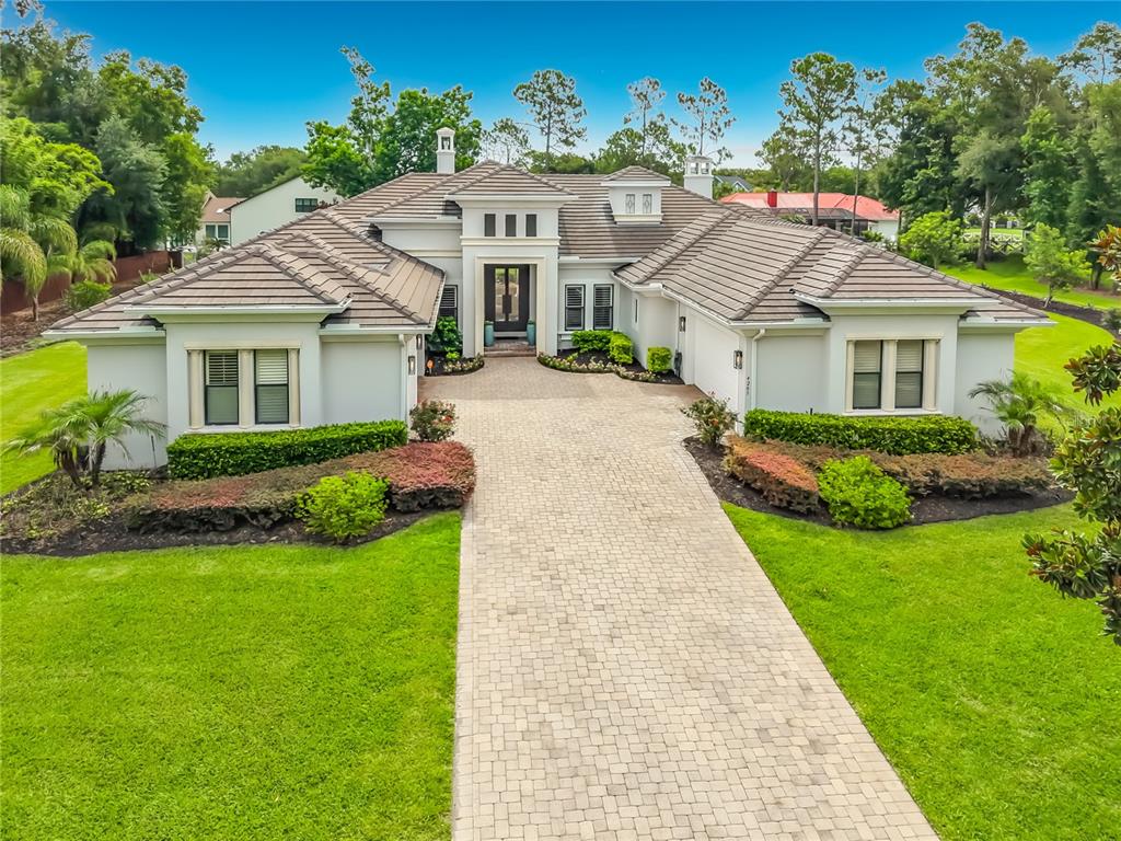 A single-story house with a tiled roof, white stucco exterior, and a paved driveway — 4205 CLARICE ESTATES DRIVE, WINDERMERE, FL