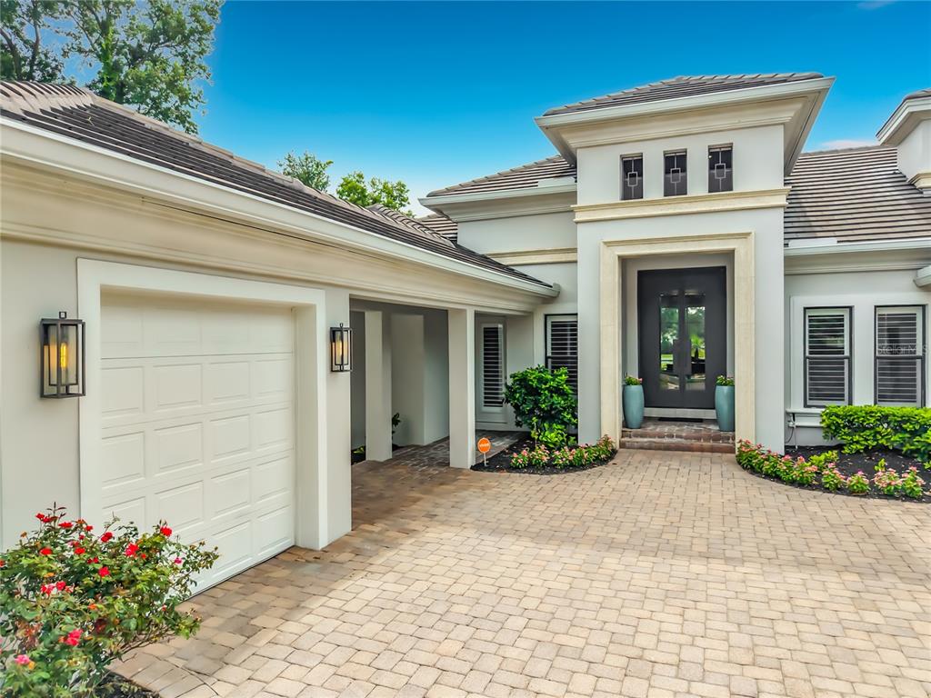 A modern house exterior features a paved driveway, a garage, and a covered front entryway — 4205 CLARICE ESTATES DRIVE, WINDERMERE, FL