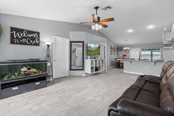 A living room with light tile floors, a large fish tank, and a brown leather sofa — 2472 PINE CHASE CIRCLE, ST CLOUD, FL
