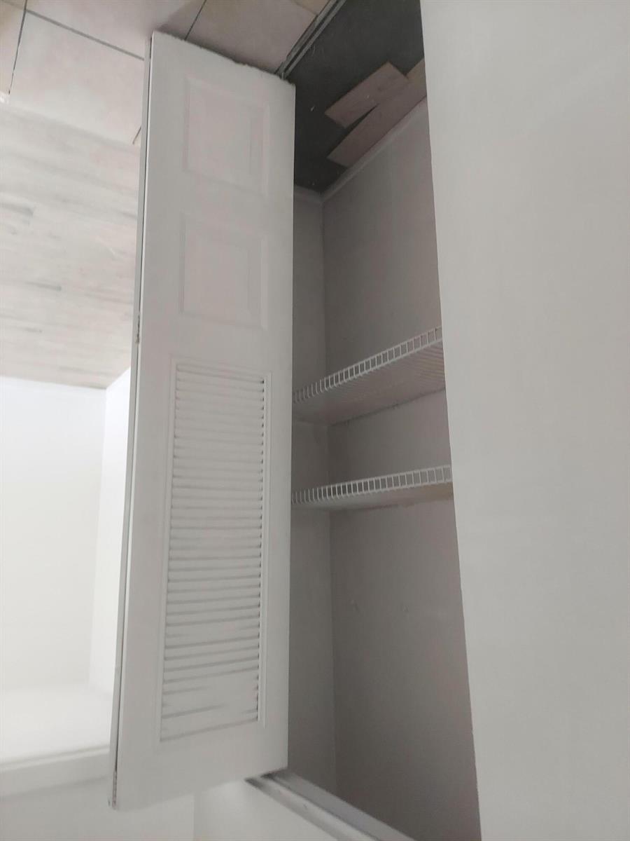 A closet with white louvered doors and two wire shelves inside a room — 2215 NW 56th Avenue # e, Lauderhill FL 33313, LAUDERHILL, FL