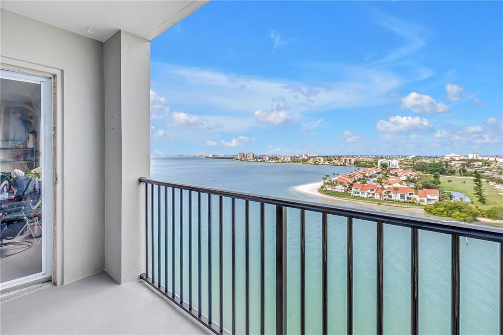 A balcony with a black metal railing overlooks a bay and a coastal residential area — 5220 BRITTANY DRIVE S UNIT 1204, ST PETERSBURG, FL