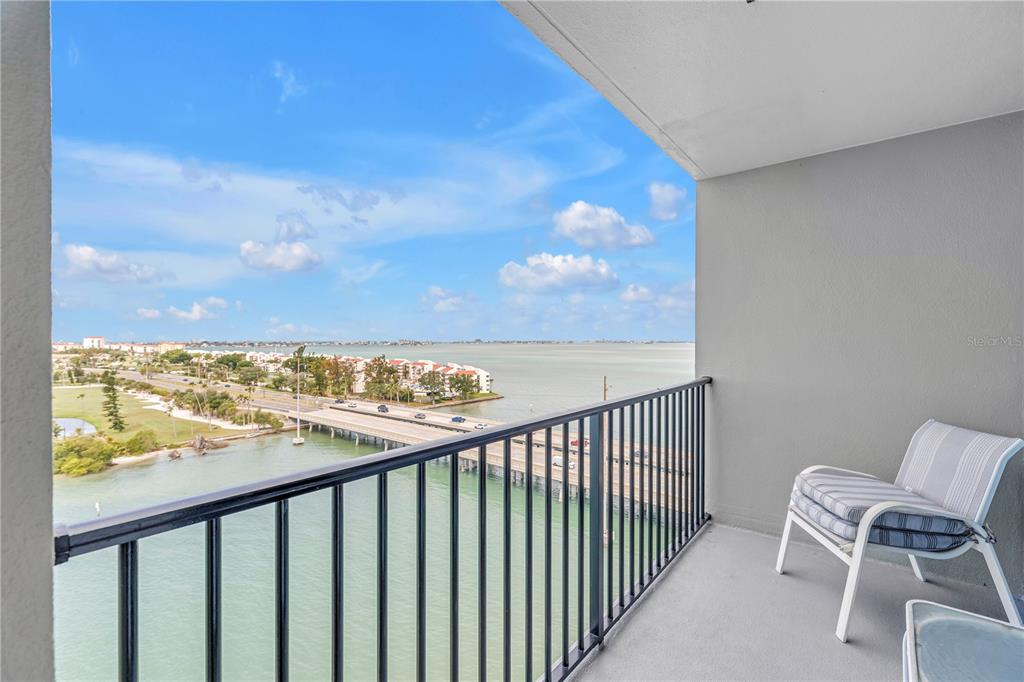 A balcony with a metal railing overlooks a bridge, water, and a coastal landscape — 5220 BRITTANY DRIVE S UNIT 1204, ST PETERSBURG, FL