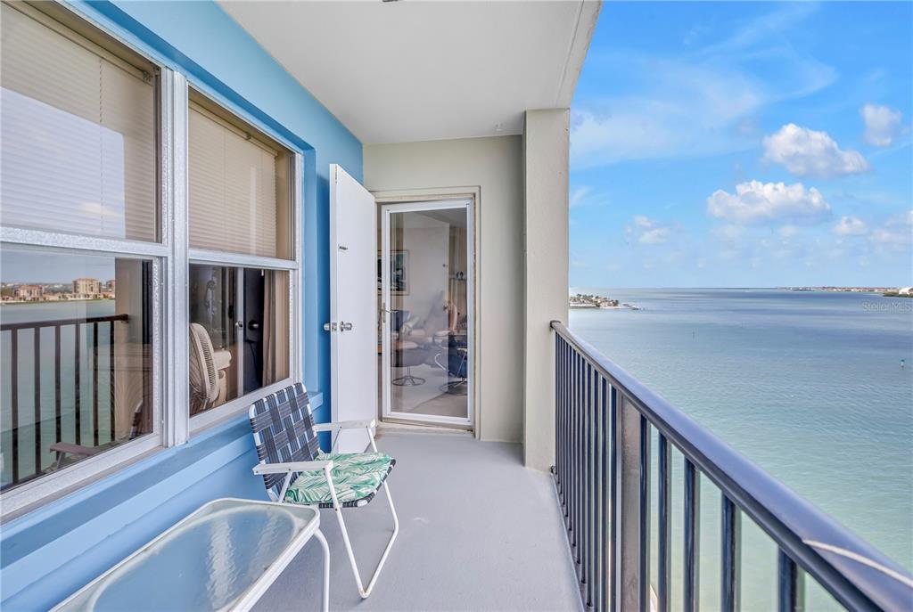 A balcony with a chair and table overlooks a large body of water — 5220 BRITTANY DRIVE S UNIT 1204, ST PETERSBURG, FL