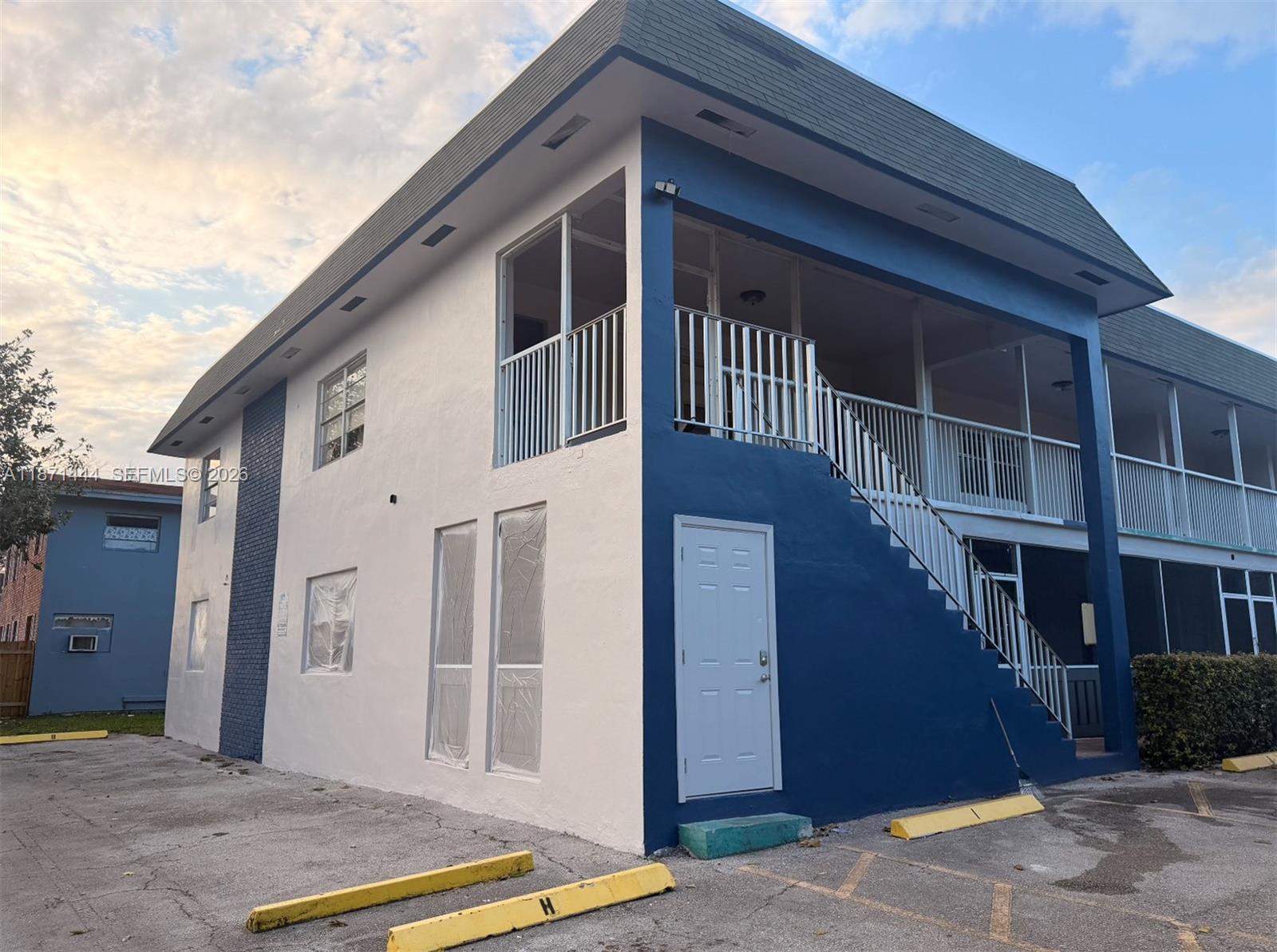 A two-story apartment building exterior features white and blue paint with an outdoor staircase — 2905 Pierce St # 17, Hollywood FL 33020, HOLLYWOOD, FL