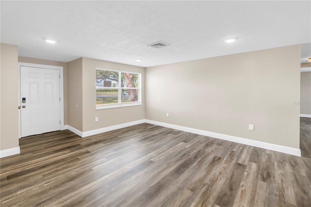 A covered front porch features stone pillars, a white door, and a concrete floor — 518 62ND AVENUE NE, ST PETERSBURG, FL