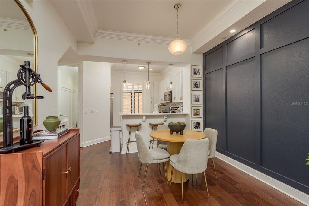 A dining area features a round wooden table, upholstered chairs, and a dark blue accent wall — 2221 SOHO BAY COURT, TAMPA, FL