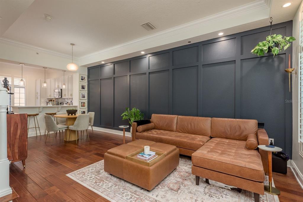 A living room features a dark blue paneled accent wall, leather sectional, and hardwood floors — 2221 SOHO BAY COURT, TAMPA, FL