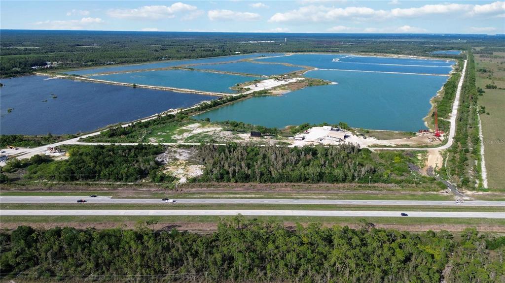 An aerial view shows a large body of water divided by land strips near a highway — 16540 TAMIAMI TRAIL, PUNTA GORDA, FL