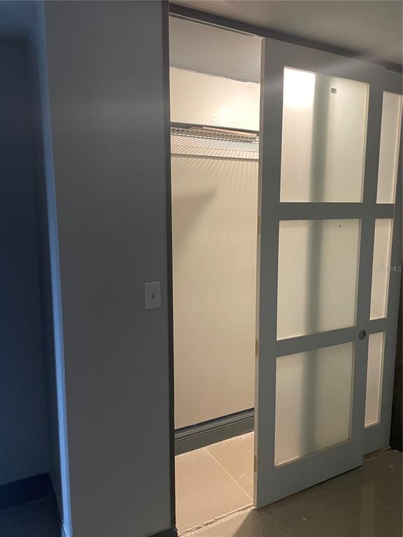 A closet with a wire shelf and a sliding door featuring frosted glass panels — 7352 BALBOA DRIVE UNIT 7352, ORLANDO, FL