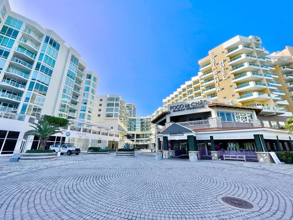 An exterior view of a multi-story hotel and restaurant complex with a paved courtyard — 15 LUIS MUÑOZ RIVERA AVENUE, SAN JUAN, PR