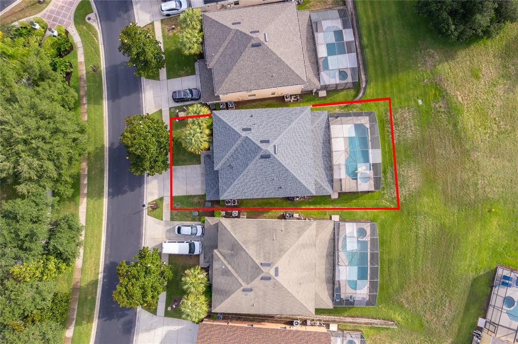 An aerial view shows a house with a pool enclosure and a red boundary line — 2717 FIESTA KEY DRIVE, KISSIMMEE, FL