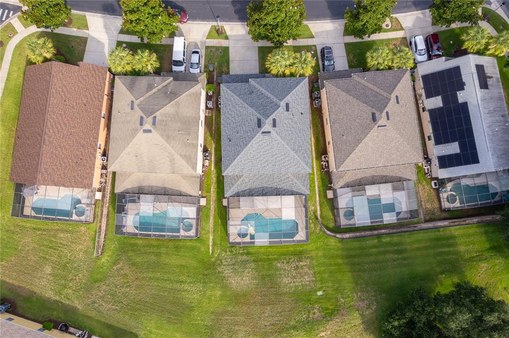 An aerial view shows four suburban houses with swimming pools and screened-in lanais — 2717 FIESTA KEY DRIVE, KISSIMMEE, FL