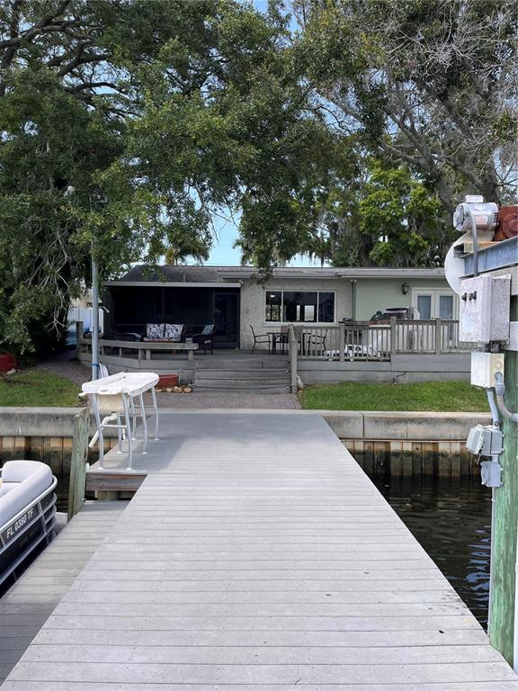 A view from a wooden dock looking toward a house with a deck and patio — 378 WESTWINDS DRIVE, PALM HARBOR, FL
