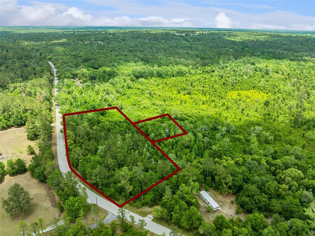 An aerial view shows a wooded lot outlined in red next to a paved road — CULBREATH ROAD, BROOKSVILLE, FL