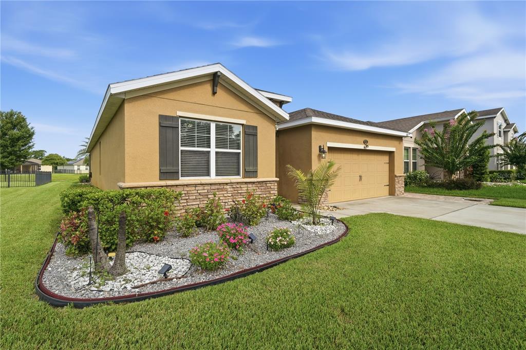 A single-story house with a tan stucco exterior, stone accents, and a two-car garage — 632 E VICTORIA TRAILS BOULEVARD, DELAND, FL