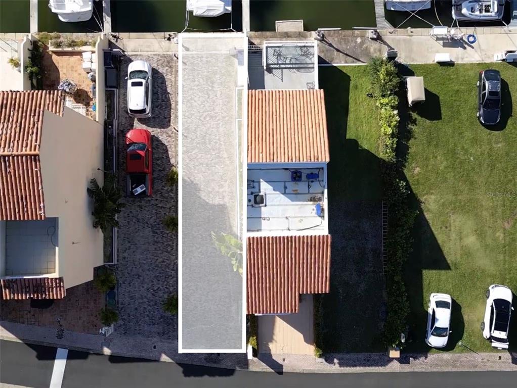 An aerial view shows a residential property with a tiled roof, driveway, and boat slips — 9 ISLA SAN MIGUEL UNIT 9, HUMACAO, PR