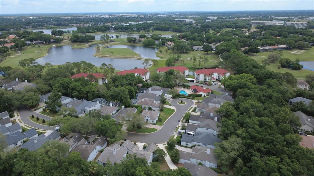 An aerial view shows a residential community with houses, apartment buildings, and a golf course — 1257 BRAMPTON PLACE, LAKE MARY, FL