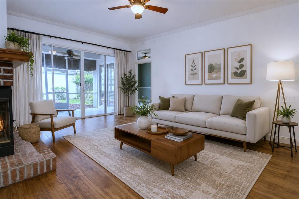 A living room features a beige sofa, wooden coffee table, fireplace, and sliding glass doors — 1257 BRAMPTON PLACE, LAKE MARY, FL