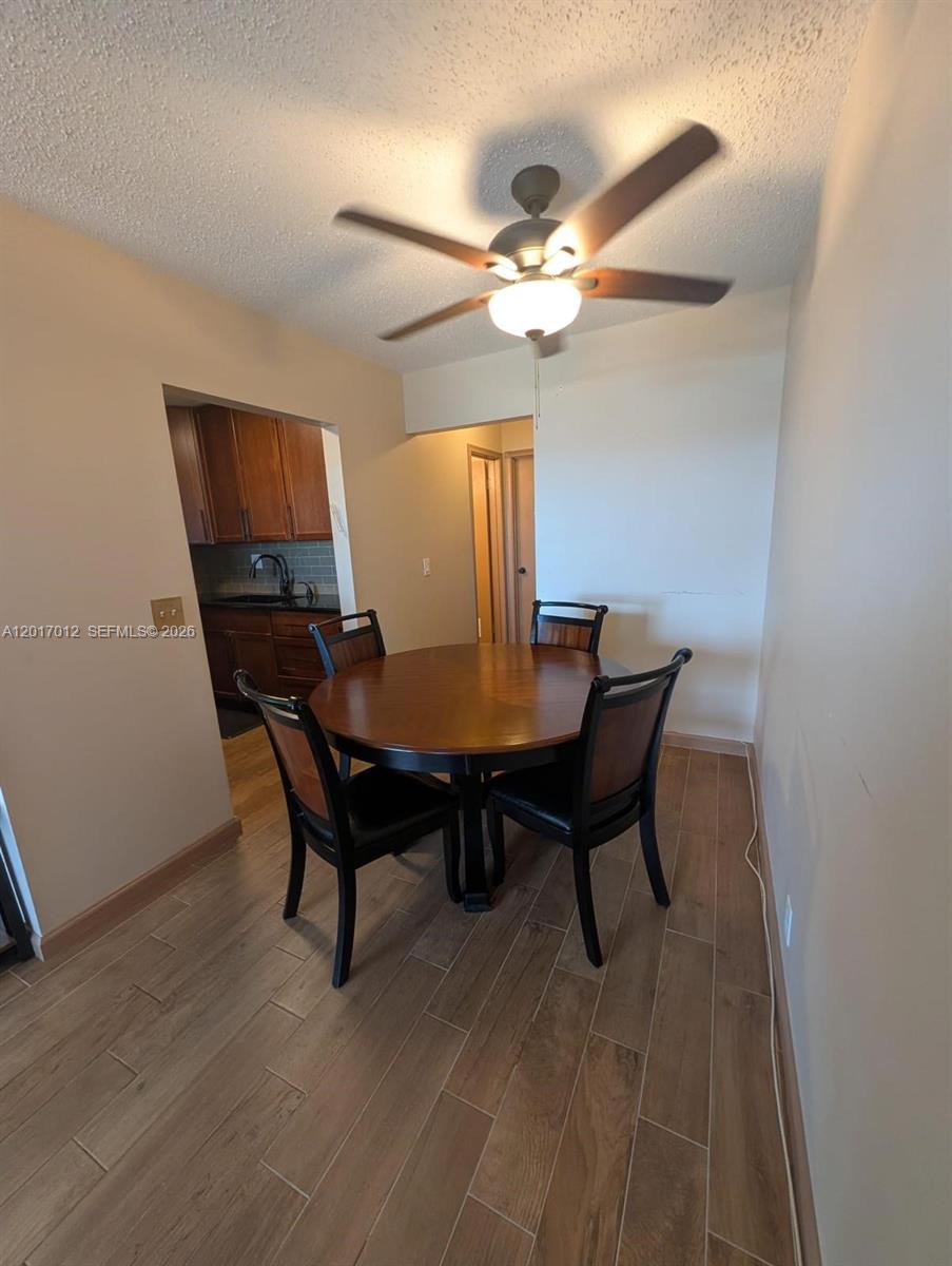 A dining area features a round wooden table, four chairs, and a ceiling fan — 23 Easthampton A # 0, West Palm Beach FL 33417, WEST PALM BEACH, FL