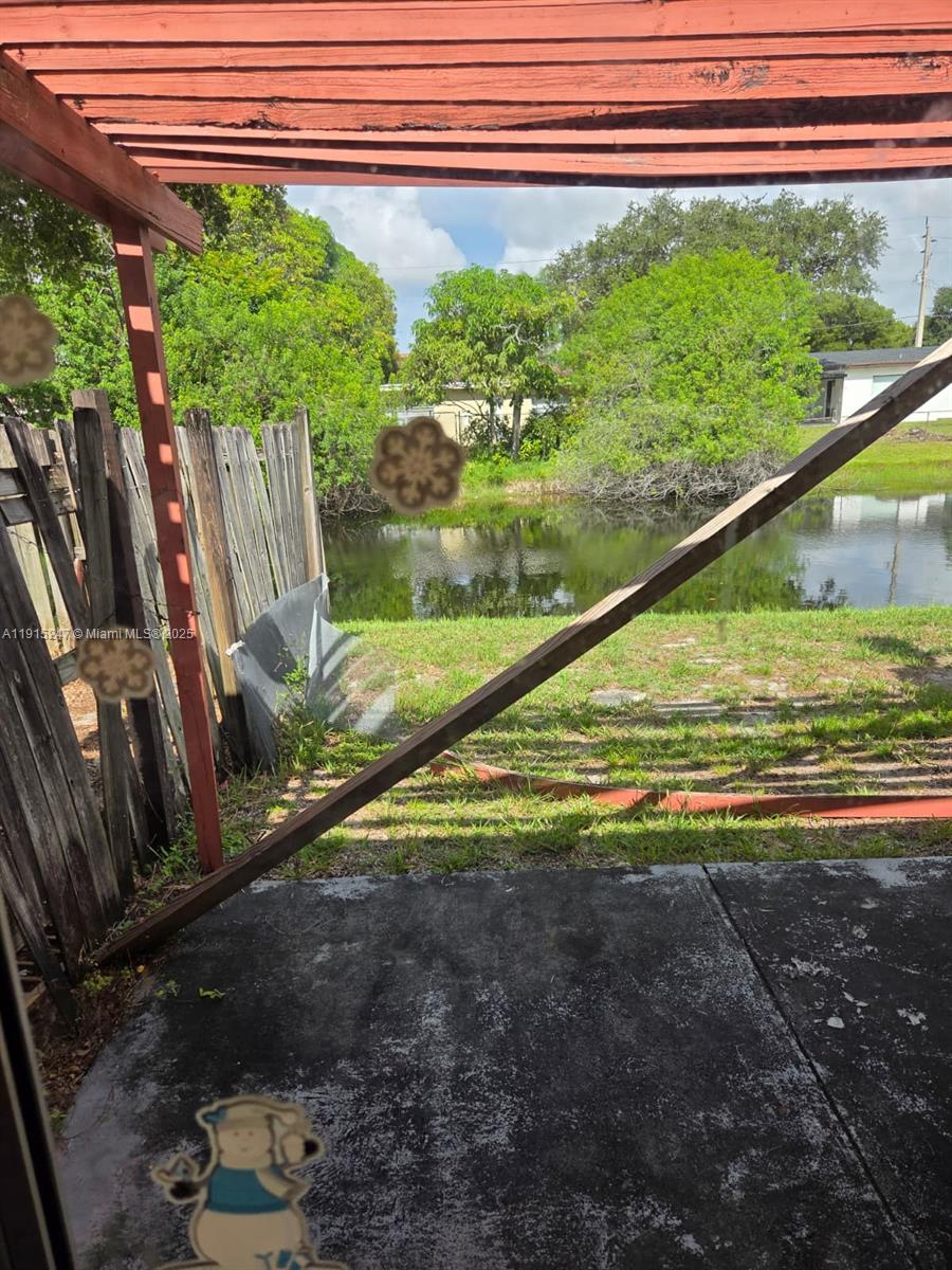 A view from a patio looking out toward a small pond and a wooden fence — 1524 NW 56th Ave # 7, Lauderhill FL 33313, LAUDERHILL, FL