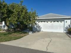 A single-story house with a white garage door and a concrete driveway under a clear sky — 2416 WATERFORD COURT, PALMETTO, FL