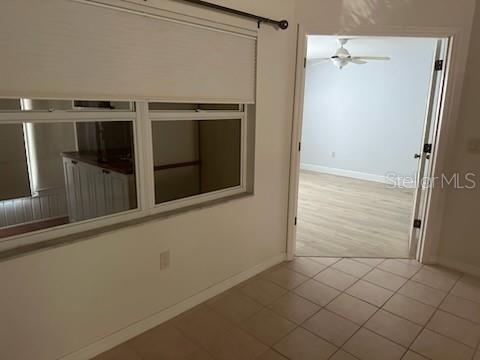 A tiled room features a large window with a shade and double doors leading to a bedroom — 2416 WATERFORD COURT, PALMETTO, FL