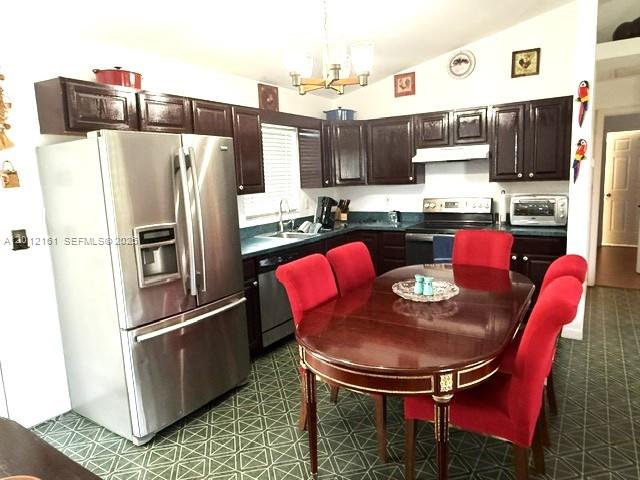 A kitchen features dark wood cabinets, stainless steel appliances, and a red-chaired dining table — 2416 Vance Ave, Lorida FL 33857, LORIDA, FL
