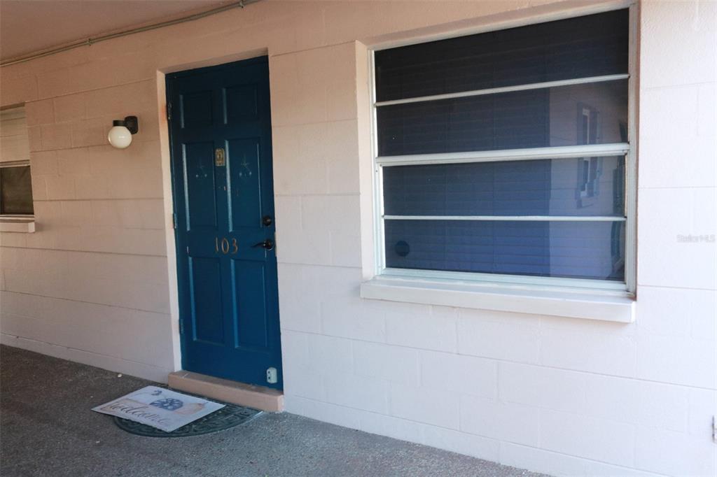 A blue front door with the number 103 and a window on a concrete building — 3125 36TH STREET N UNIT 103, ST PETERSBURG, FL