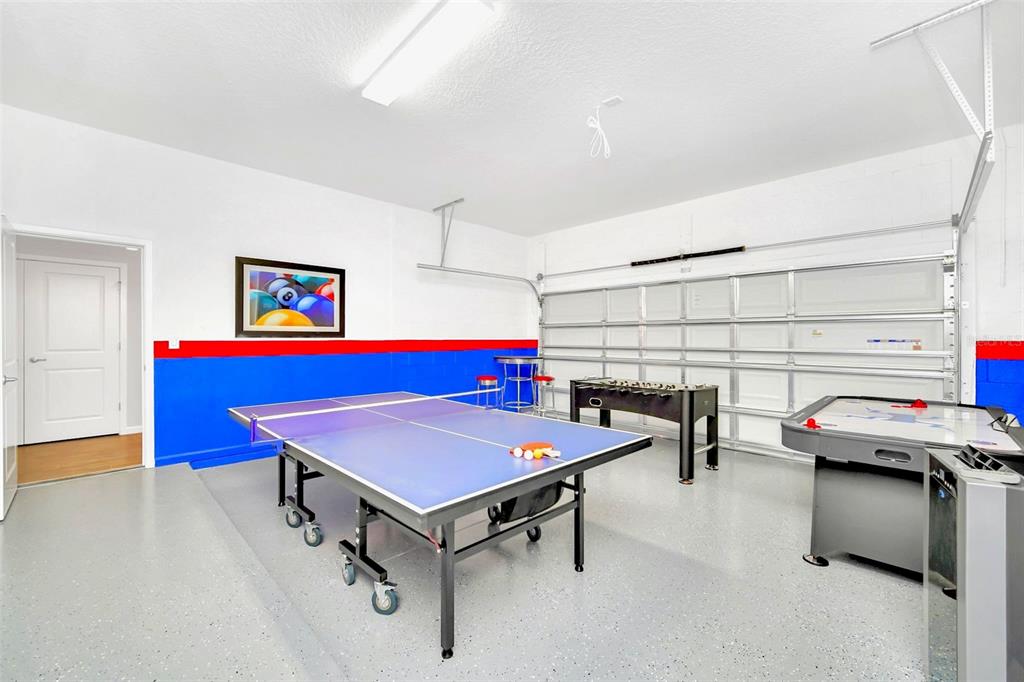 A garage converted into a game room with a ping pong table, foosball, and air hockey — 2567 SHANTI DRIVE, KISSIMMEE, FL