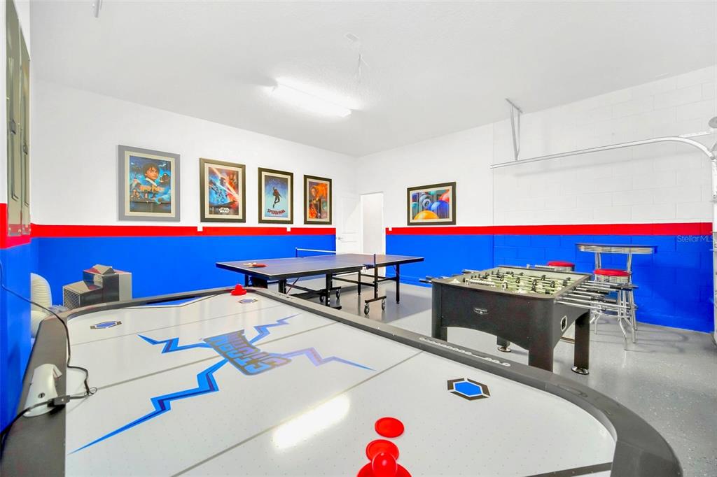 A garage converted into a game room with an air hockey table, ping pong table, and foosball — 2567 SHANTI DRIVE, KISSIMMEE, FL