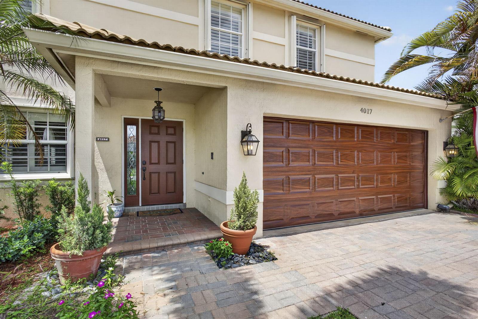 The exterior of a two-story house features a brown garage door and a front entrance — 4017 Bluff Harbor Way, Wellington FL 33449, WELLINGTON, FL