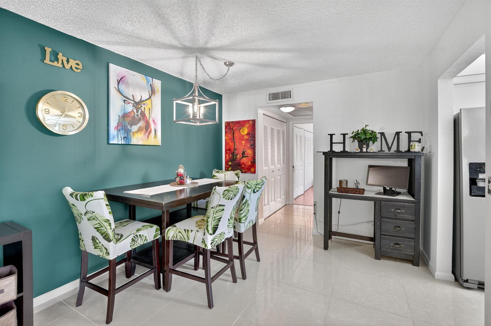 A dining area features a teal accent wall, a dark wood table, and patterned chairs — 425 Durham N, Deerfield Beach FL 33442, DEERFIELD BEACH, FL
