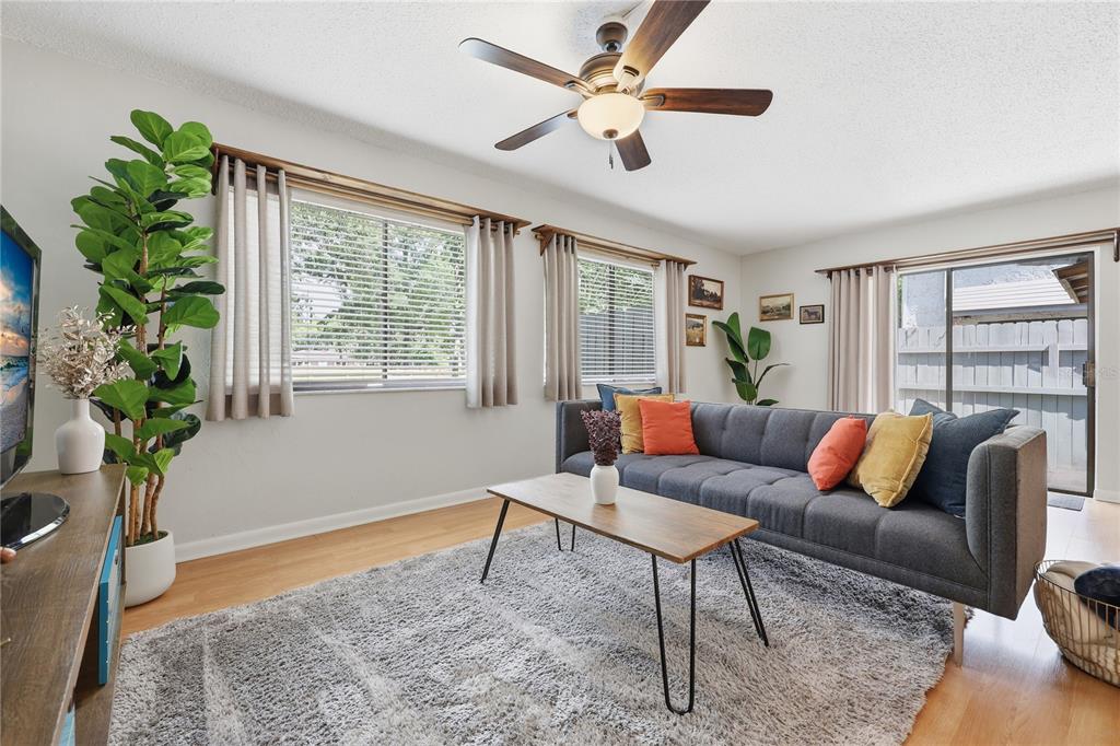 A living room features a gray sofa, a wood coffee table, and a ceiling fan — 4109 NW 43RD TERRACE UNIT 69, GAINESVILLE, FL