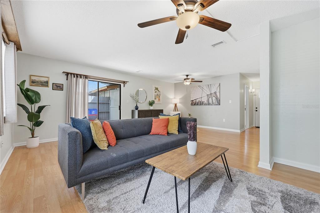 A living room features a gray sofa, wood coffee table, and light wood flooring — 4109 NW 43RD TERRACE UNIT 69, GAINESVILLE, FL